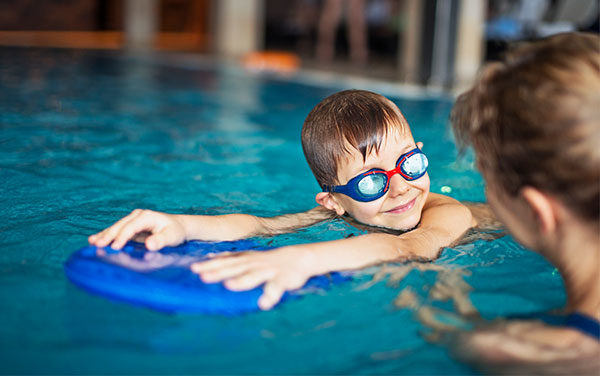 Young boy receiving swimming lesson