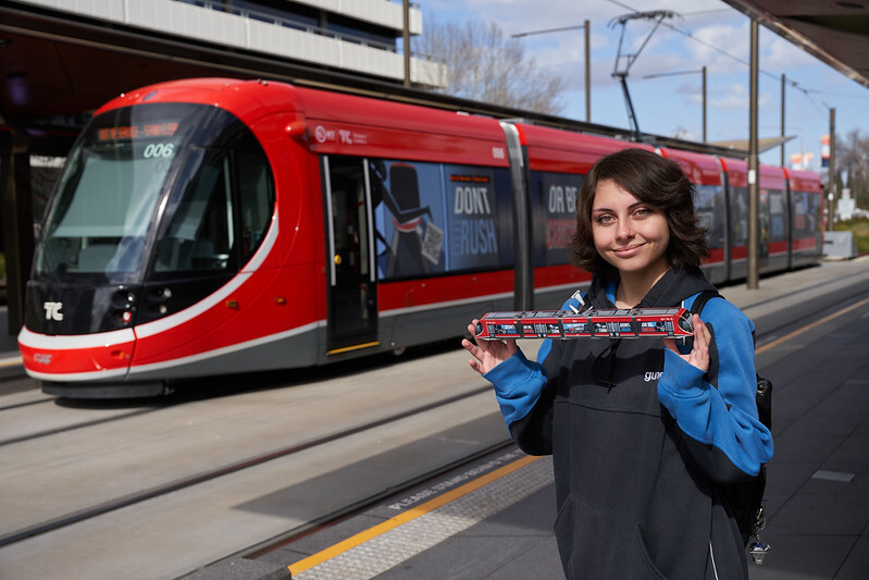 Ada Miller standing next to tram with light rail model