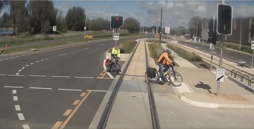 Bikes in front of tram on light rail tracks
