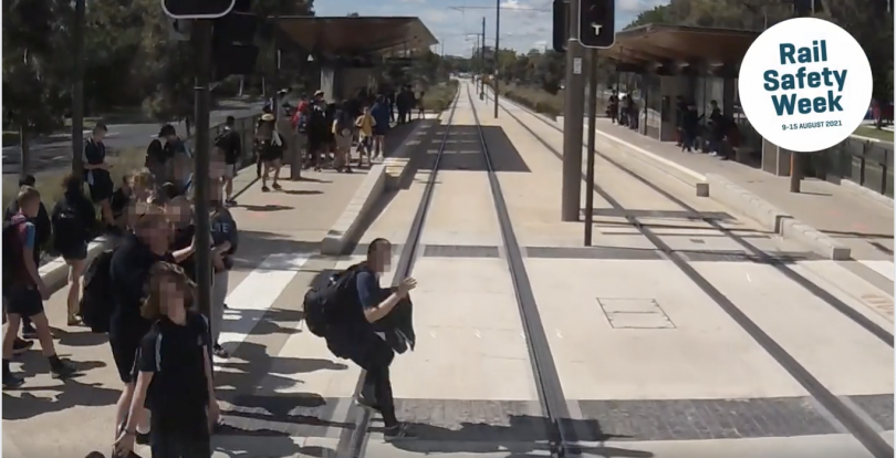 Person stepping in front of tram on light rail tracks