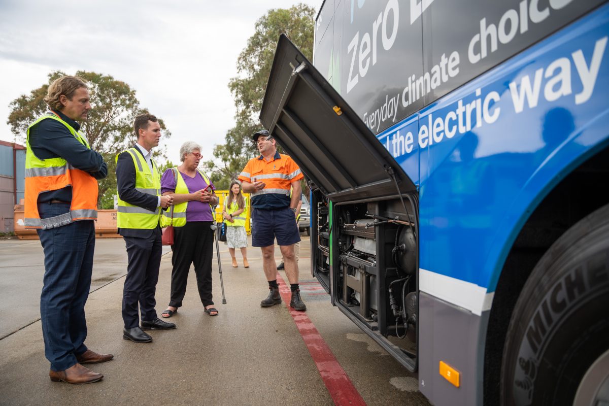 people inspecting electric bus