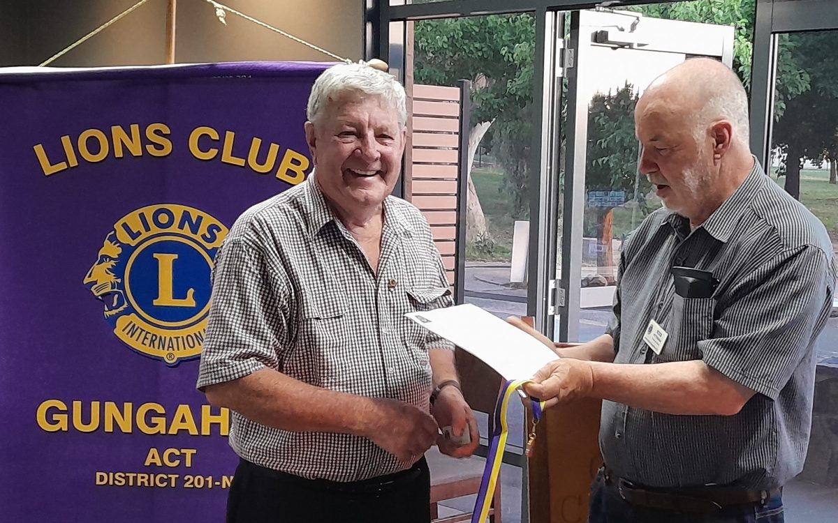 President of Gungahlin Lionss Club Ross Pettersson (right) handing over Peter Sillis' (left) medal and letter in recognition of his 50 years of service.