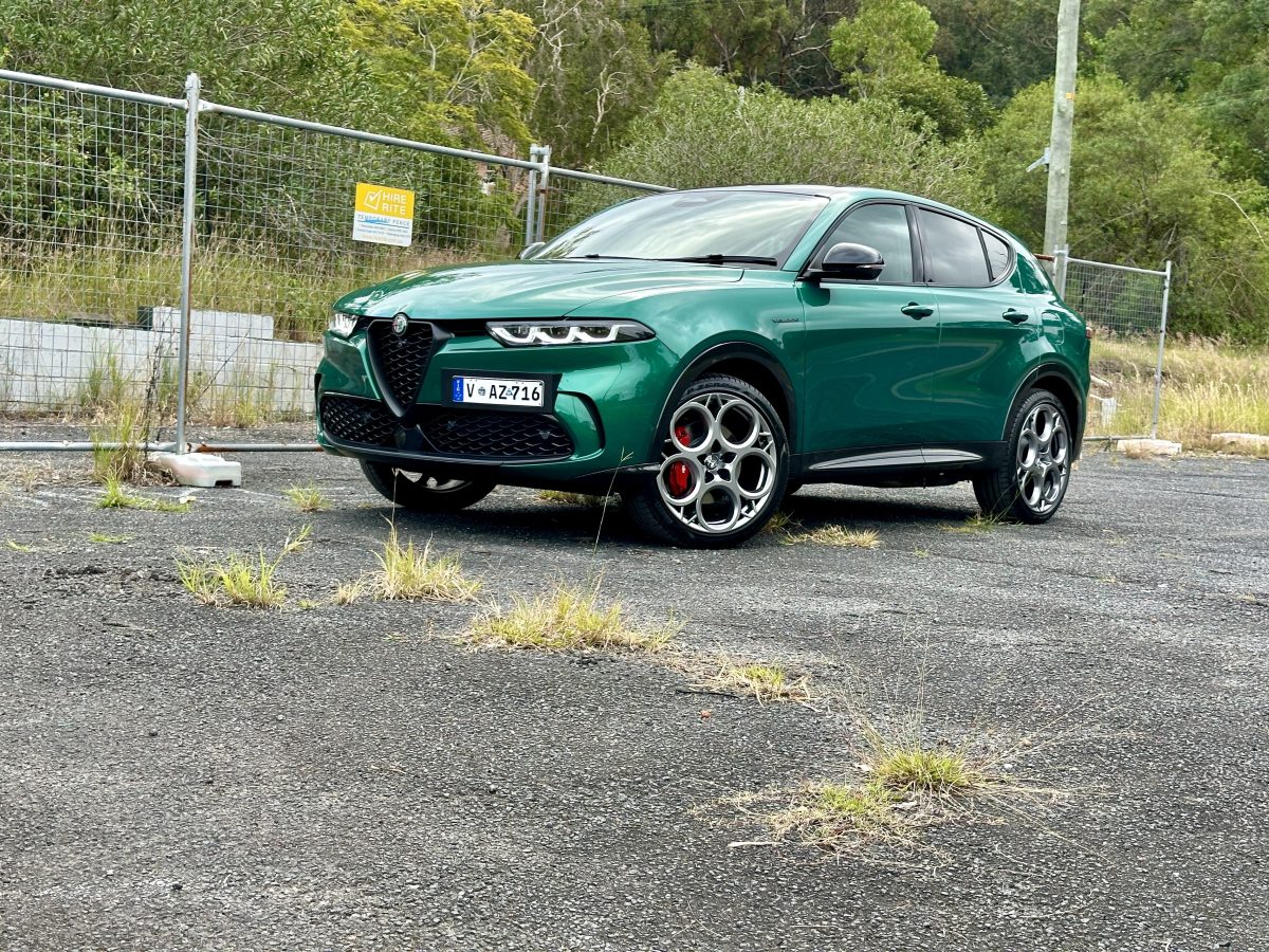 green Alfa Romeo SUV near a chainlink fence