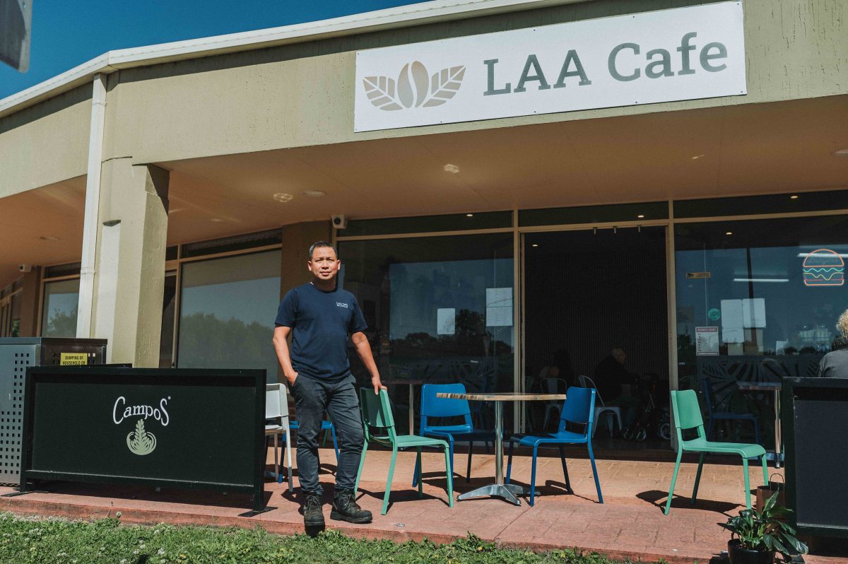 man standing outside cafe