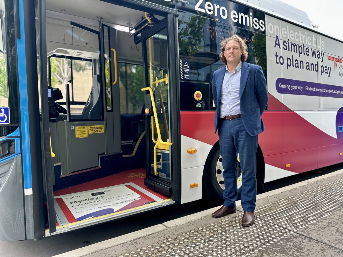 man standing next to a bus